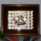 Framed artwork with 'WINNERSCLUB.JP' text on a table with branded paper.
